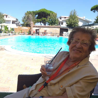 signora felice a bordo piscina